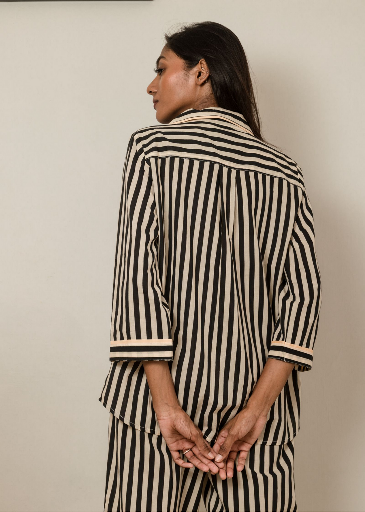 Woman wearing Black Satori print button-down pajama set with beige piping, premium cotton sleepwear
