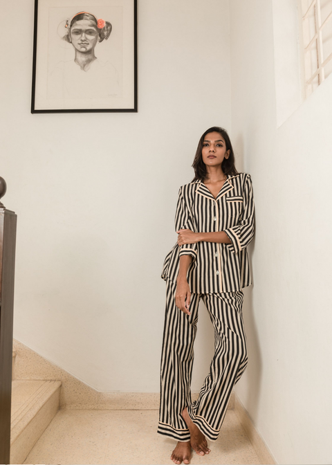 Woman wearing Black Satori print button-down pajama set with beige piping, premium cotton sleepwear